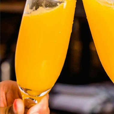 Two mimosa glasses clinking