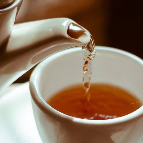 Tea being poured into a white cup